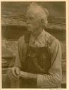 A signed Doris Ulmann wax platinum print of an old man in front of a log cabin