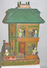 A lithographed two-story dollhouse with side bay windows, a wrap-around porch, widow's walk, balcony, a mansard roof with three dormers and original interior wallpaper, along with four German painted bisque dollhouse dolls