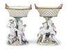 A pair of Marcolini Period first quality Meissen compotes of basket form supported by standards with two putti