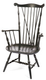 A New England comb-back, brace-back windsor armchair having carved ears and knuckles, baluster turnings and black-painted surface