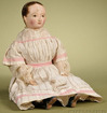 An Izannah Walker painted cloth Child, having an oil-painted stockinette head and shoulders, hand-painted features including brown eyes, brown painted hair with center part, seven back corkscrew curls and finely brush stroked wisps of hair above applied ears, pierced nostrils, pink cheek blush and a painted closed mouth