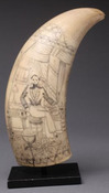 A scrimshaw decorated whale tooth with image of a seated ship captain with globe attributed to the Ceres Artisans of Wilimington, Delaware