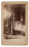 Albumen photograph of Chief Quanah Parker posing with portrait of his mother, Cynthia Ann Parker, and his sister, Prairie Flower