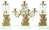 A three piece cast brass Paul and Virginia girandole set with white marble bases and cut, paneled prisms