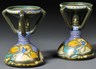 A pair of Zuid Holland Gouda Rhodian Ina Pattern pottery candlesticks, Netherlands, date ciphers for 1921, each with circular drip cup over narrow stem joined by four angular handles