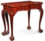 A circa 1770 Chippendale mahogany card table having a serpentine top with square candle corners, a gadrooned skirt and five cabriole legs terminating in ball & claw feet
