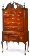 A Boston mahogany bonnet-top Queen Anne highboy having two fan carved drawers, flame finials and pendant drops