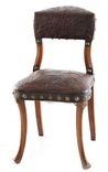 A late-19th century cockfighting chair in embossed leather, on shaped splayed legs