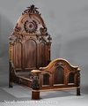 A walnut Renaissance Revival bed attributed to Mitchell and Rammelsberg of Cincinnati, Ohio, late 19th century, part of a bedroom suite also including a dresser and washstand