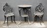 A cast-iron garden set consisting of two chairs and a circular table, the table marked for Hinderer's Iron Works, New Orleans, late 19th century