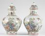A pair of Chinese famille rose decorated porcelain vases and covers, decorated with phoenix among peonies