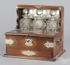 An oak English Tantalus with three decanters