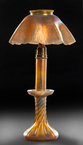 TIFFANY FAVRILE CANDLESTICK LAMP WITH SHADE. First quarter 20th century. Twist base with brass harp supporting a ruffled shade